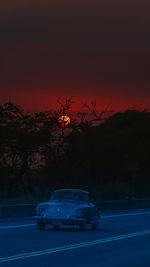 Cars on road against sky at night