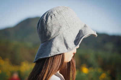 Side view of woman wearing hat against sky