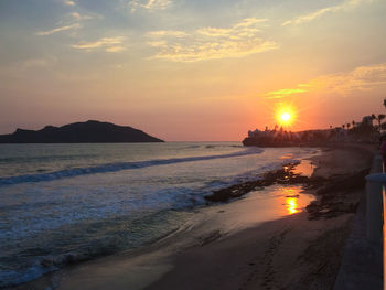 Scenic view of beach against sky during sunset