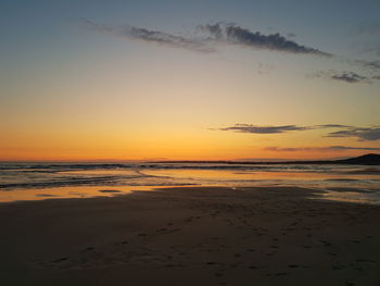 Scenic view of beach against sky during sunset