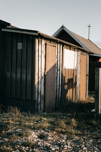 Old wooden house on field against sky