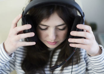 Close-up of young woman wearing headphones at table