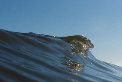 Close-up of sea against clear blue sky