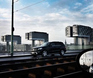 Cars on road in city against sky