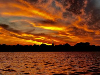 Scenic view of dramatic sky over lake during sunset