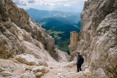 Side view of man standing on rocks against mountains