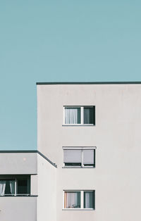 Three windows of a prefabricated building against clear sky in berlin spandau.