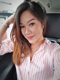 Portrait of beautiful young woman in car