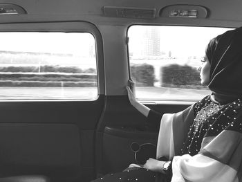 Rear view of woman sitting in car