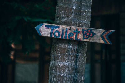 Close-up of text on wooden post