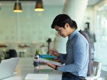 Side view of young businessman working at office