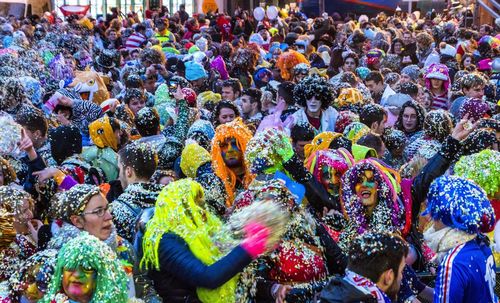 Crowd throwing colorful confetti in city during celebration