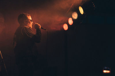 Rear view of man standing against black background