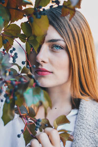 Close-up portrait of young woman by plants