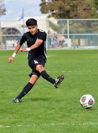 Full length of woman playing soccer ball on grass