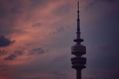 Communications tower against cloudy sky