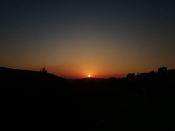 Silhouette landscape against clear sky during sunset