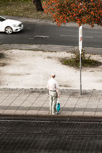 High angle view of man standing on sidewalk