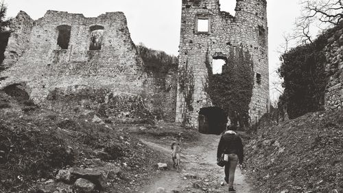 Rear view of man walking on old ruin