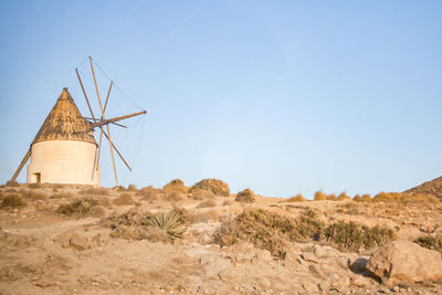 Traditional windmill on field against clear sky