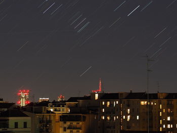 Illuminated buildings against sky at night