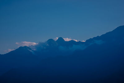 Scenic view of mountains against blue sky