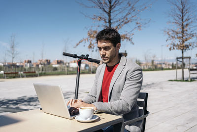 Man holding coffee cup on table