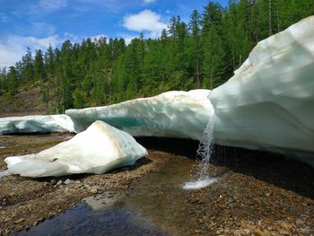 Scenic view of waterfall against sky