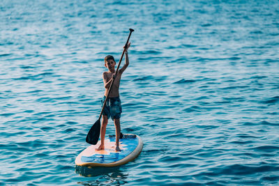 Man holding boat in sea