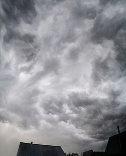 Low angle view of buildings against cloudy sky