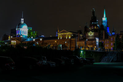 Traffic on road against buildings in city at night