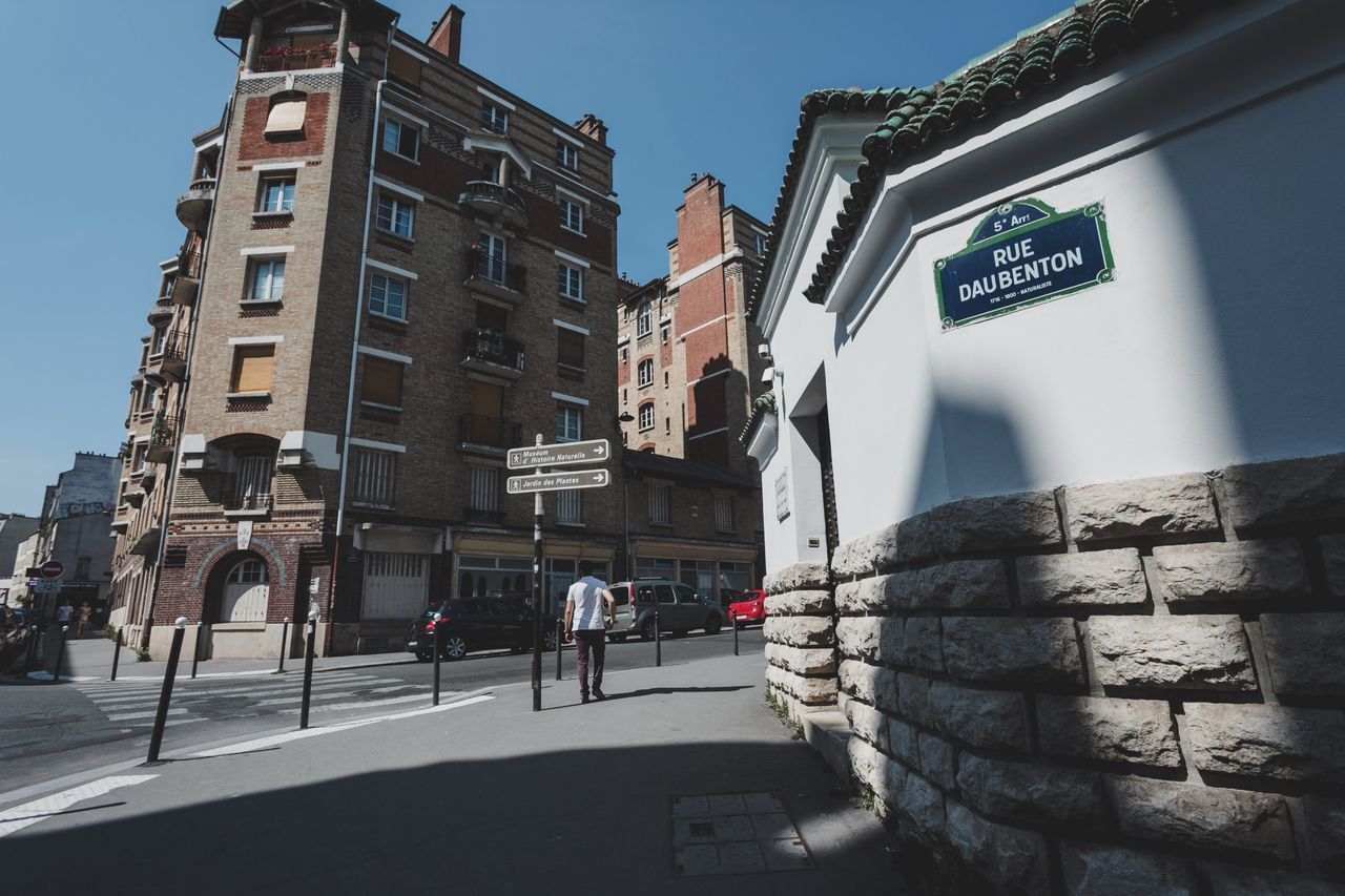 LOW ANGLE VIEW OF ROAD SIGN AGAINST BUILDINGS