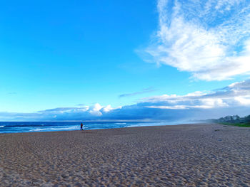 Scenic view of beach against blue sky