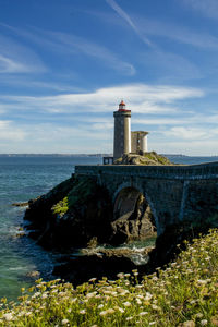 Tower by sea against sky