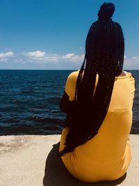 Rear view of woman looking at sea against sky