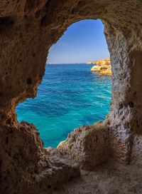 Scenic view of sea seen through cave