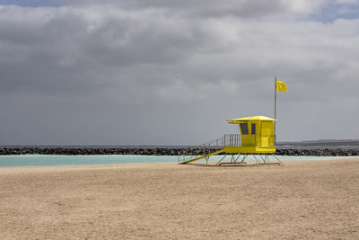 Lifeguard hut on beach against sky