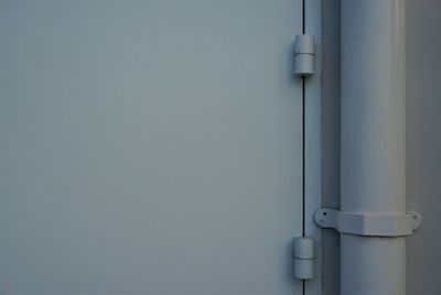 Close-up of pipe by metal door