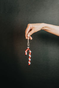 Cropped hand of woman holding candy cane