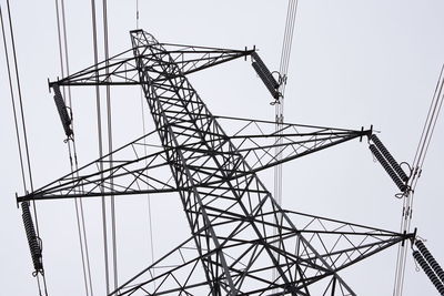 Low angle view of electricity pylon against clear sky