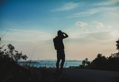 Silhouette man standing on beach against sky