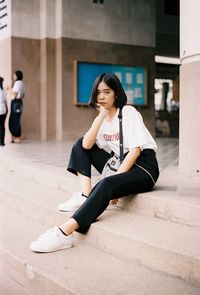 Portrait of young woman sitting outdoors