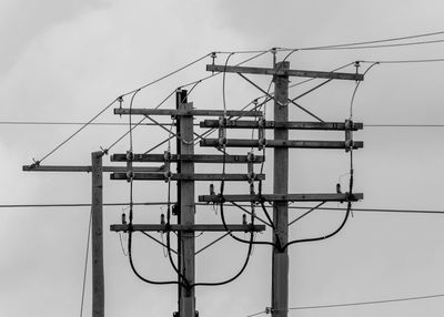 Low angle view of electricity pylon against sky