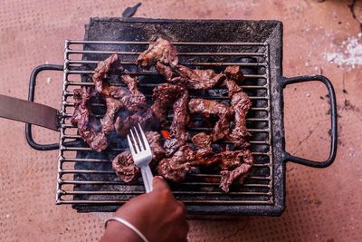 High angle view of man preparing food on barbecue grill