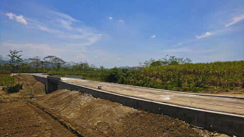 Railroad tracks by road against sky