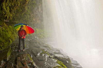 Woman behind sgwd yr eira waterfall in the brecon beacons in wales