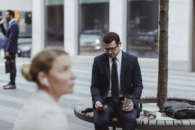 Entrepreneur using mobile phone while sitting in city