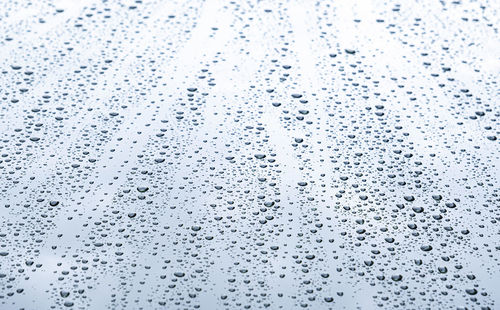 Close up rain drop on surface of car's body after passed from rainy area