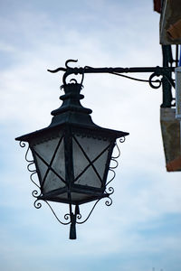 Low angle view of lamp hanging against sky