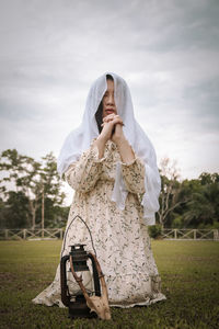 Woman standing on field against sky